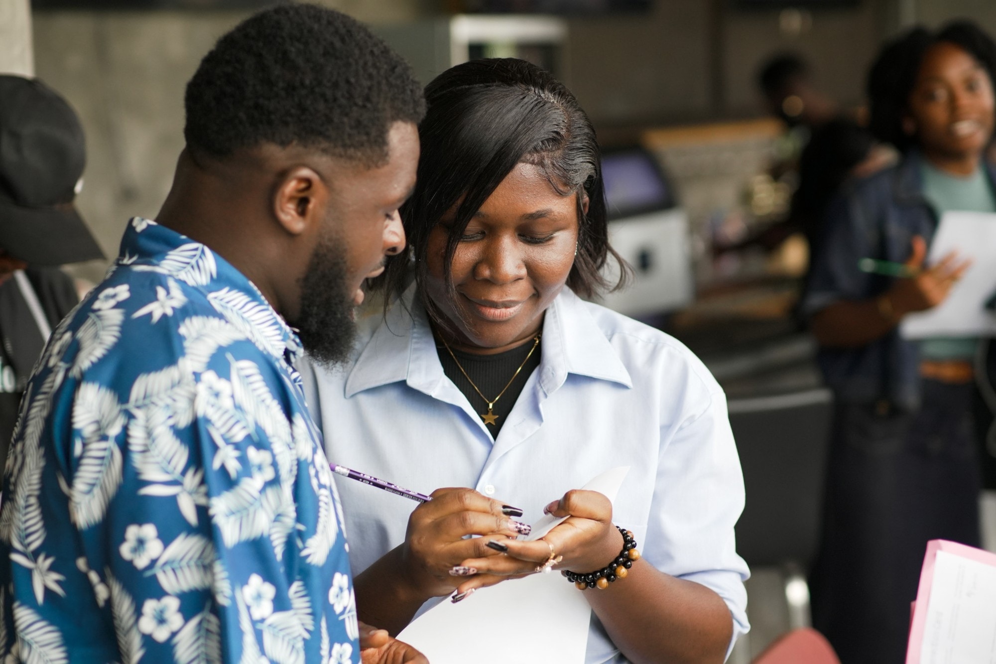 Une jeune femme prend des notes en discutant avec un pair lors d’une session de networking