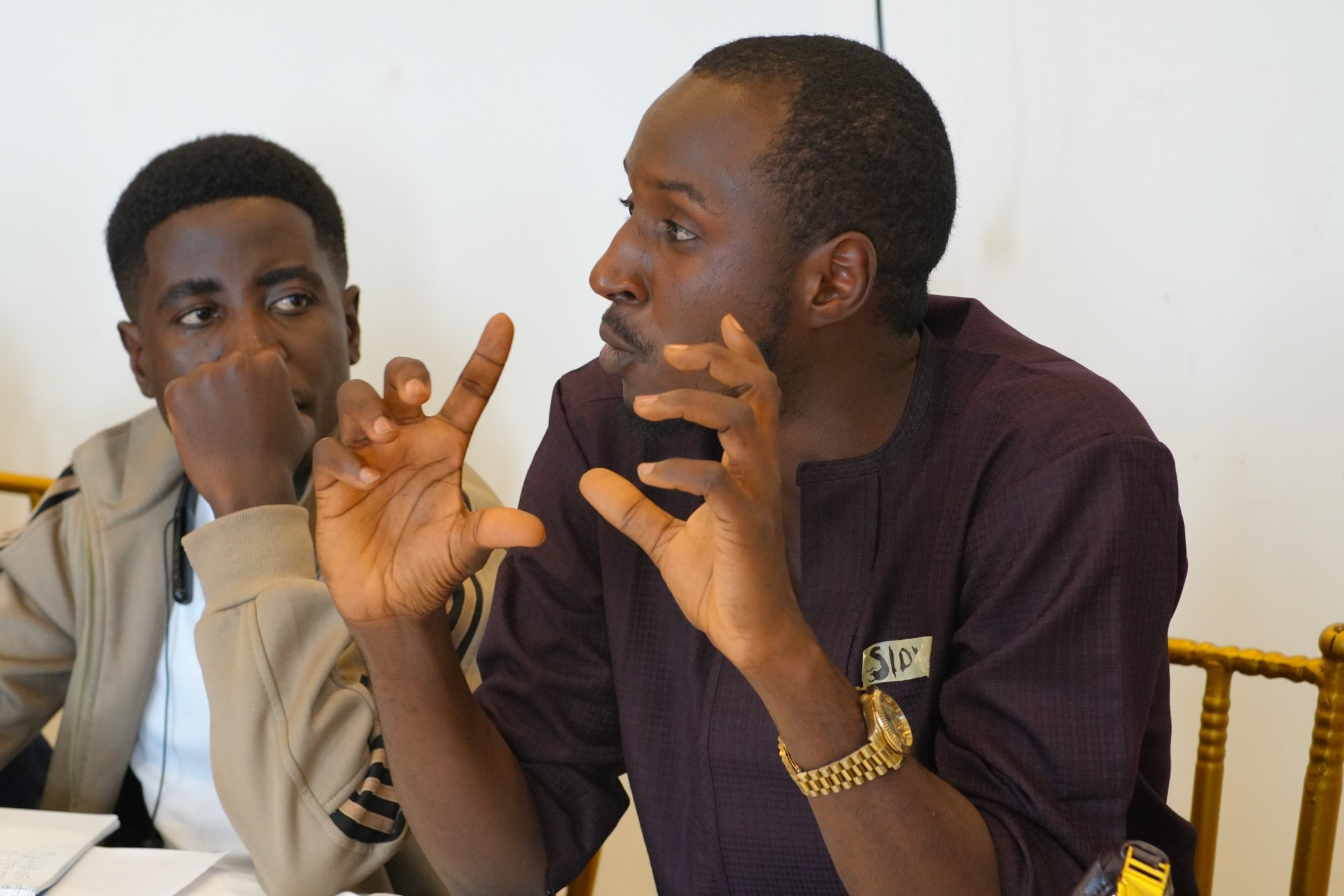 Two fellows in discussion, one gesturing as he explains an idea